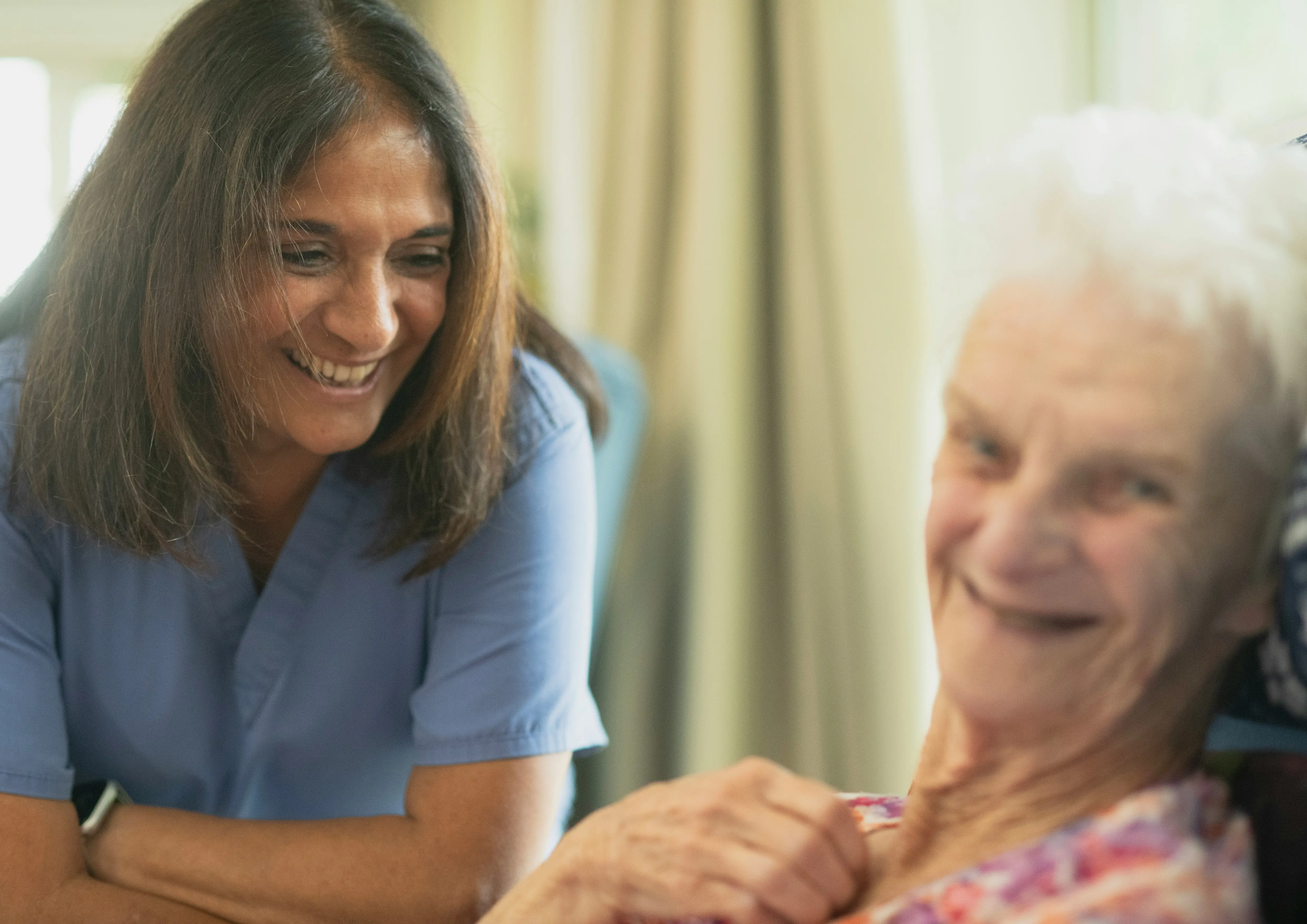 Caregiver laughing with senior